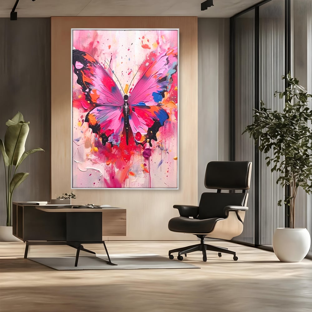 Tablou canvas cu pictura digitala cu fluture roz, in rama de aluminiu argintiu, pe perete intr-un birou